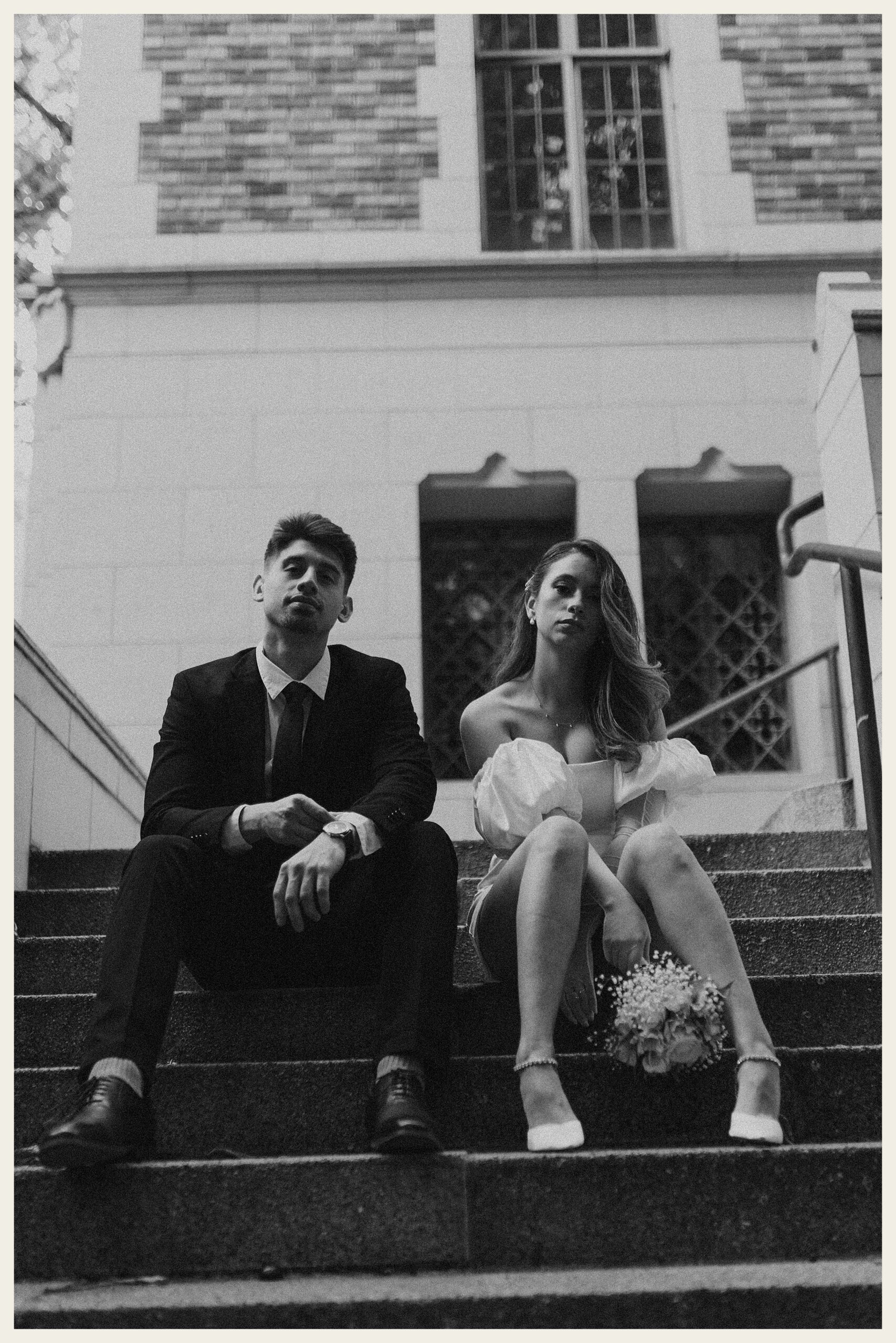 bride and groom sitting on steps UW suzzallo library 