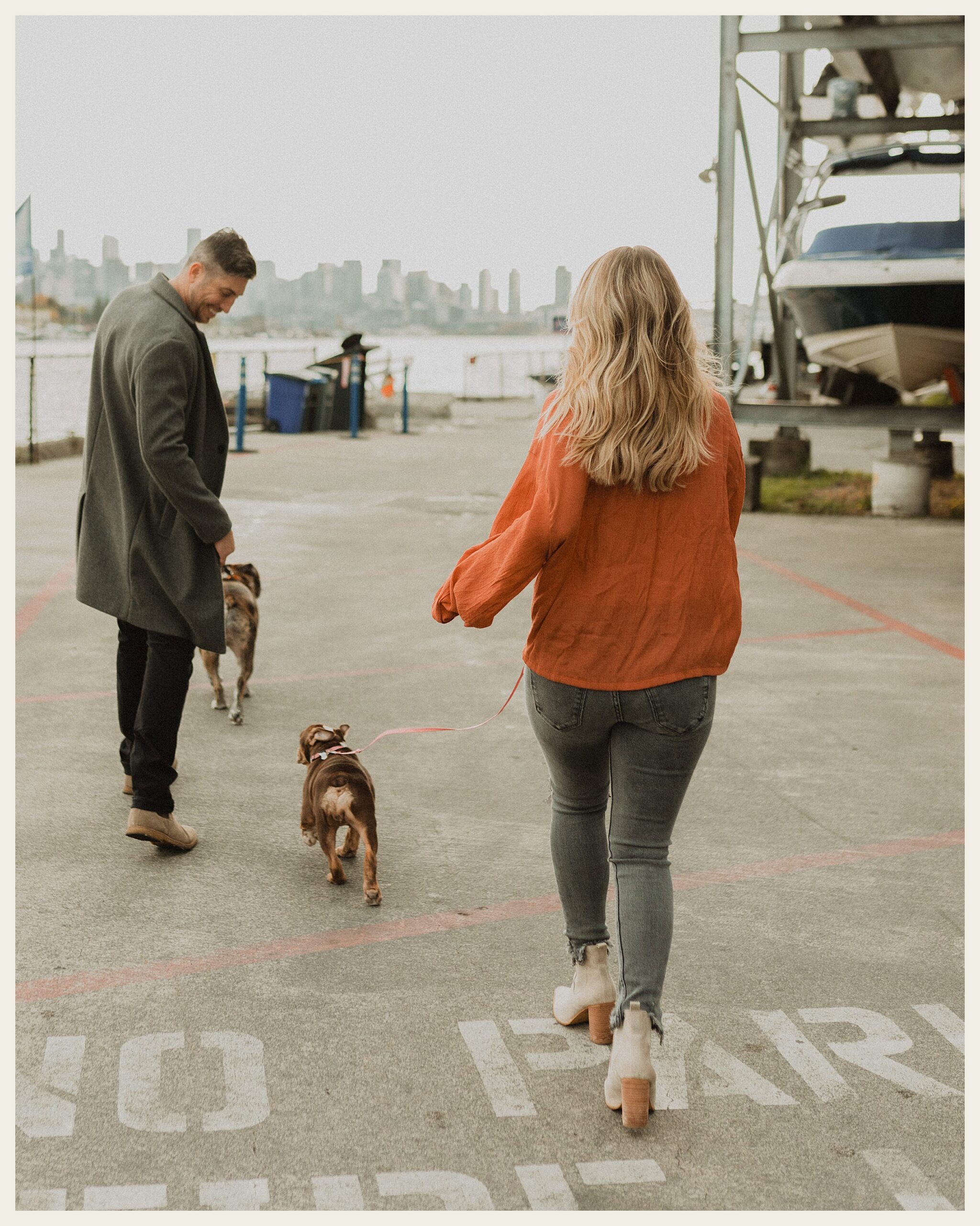 couple walking dogs on boat dock