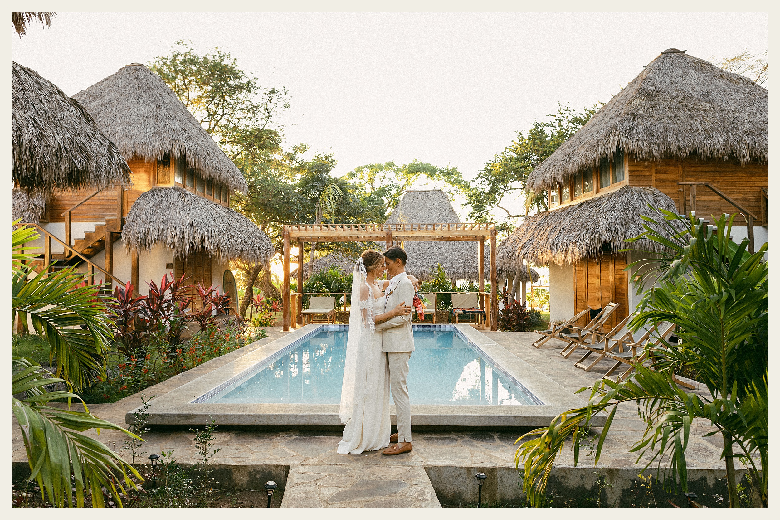 brides kissing in front of pool